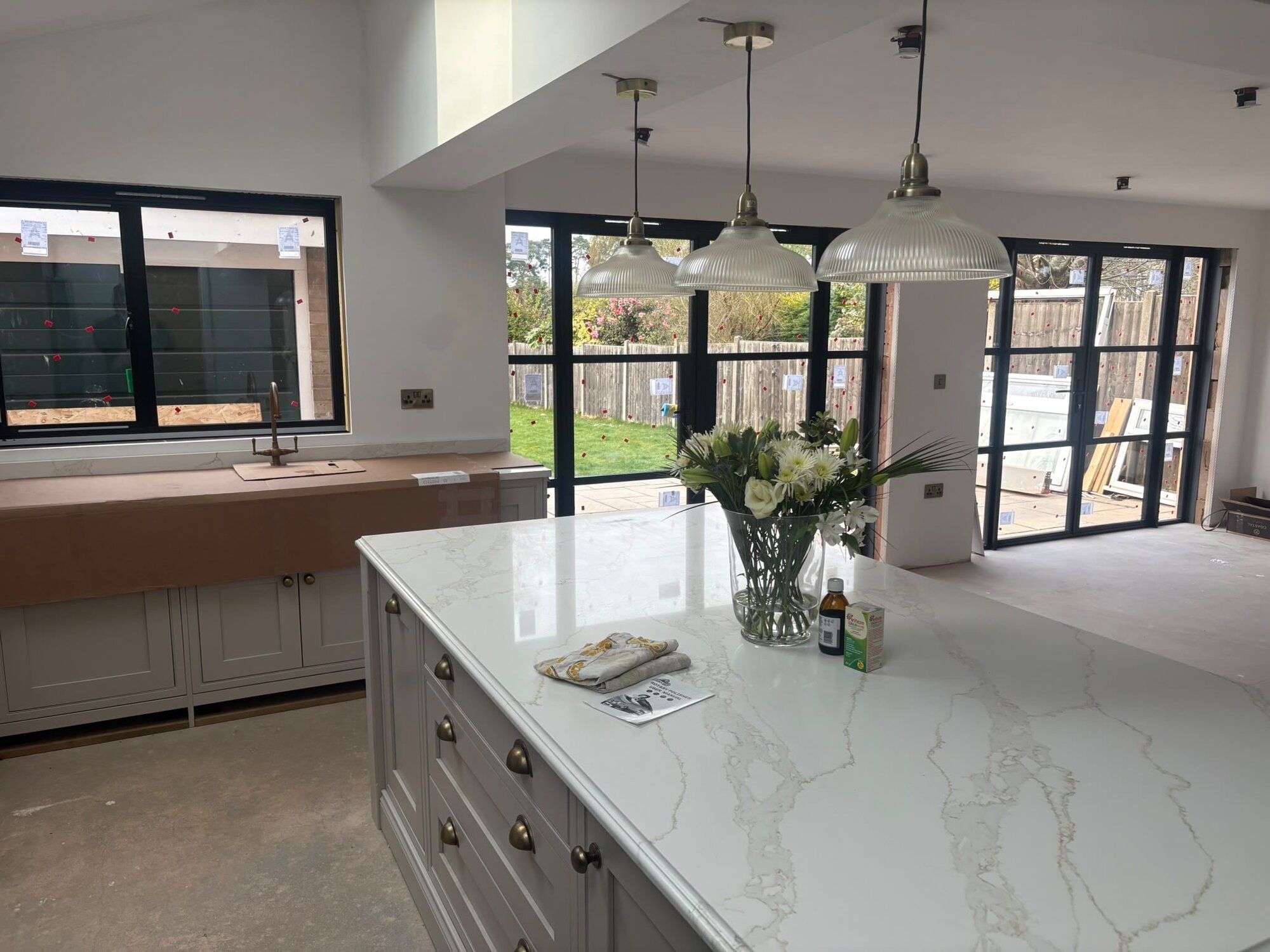 Open-plan kitchen extension with marble island and steel-framed glazing, built by Sound Build